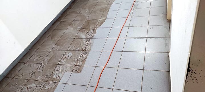 Machine cleaning of a tiled corridor: dirty floor on the left, clean on the right